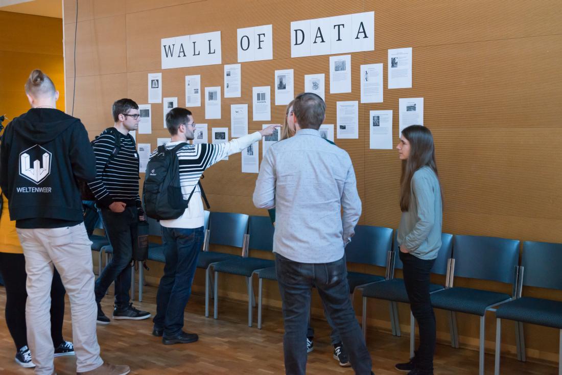 Mehrere Teilnehmende lesen Aushänge an der so genannten Wall of Data