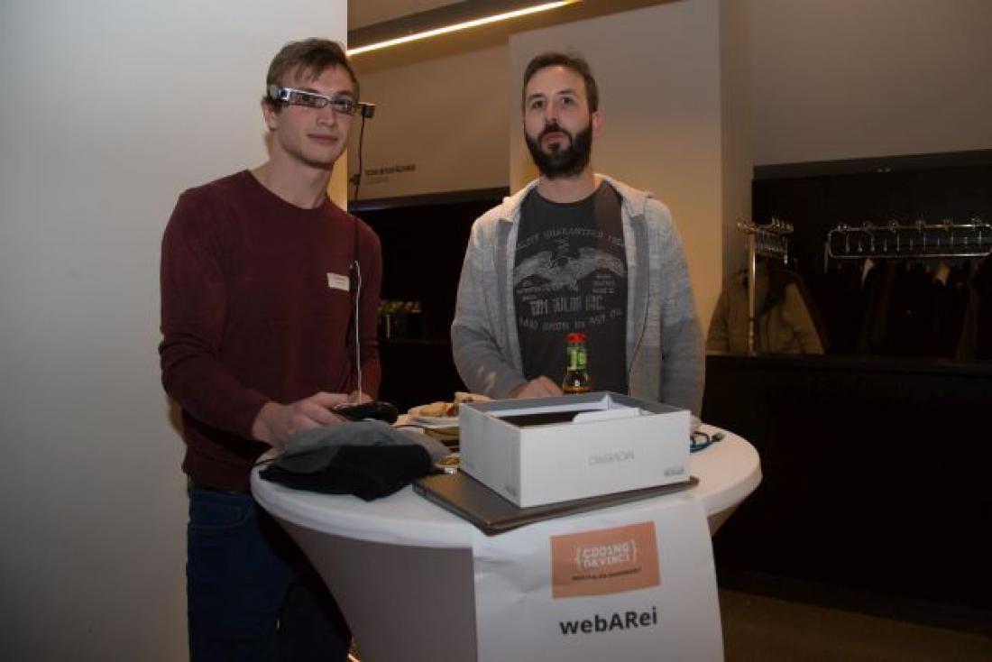 Zwei Teilnehmer von Coding da Vinci Westfalen-Ruhrgebiet präsentieren ihr Projekt an einem Stand