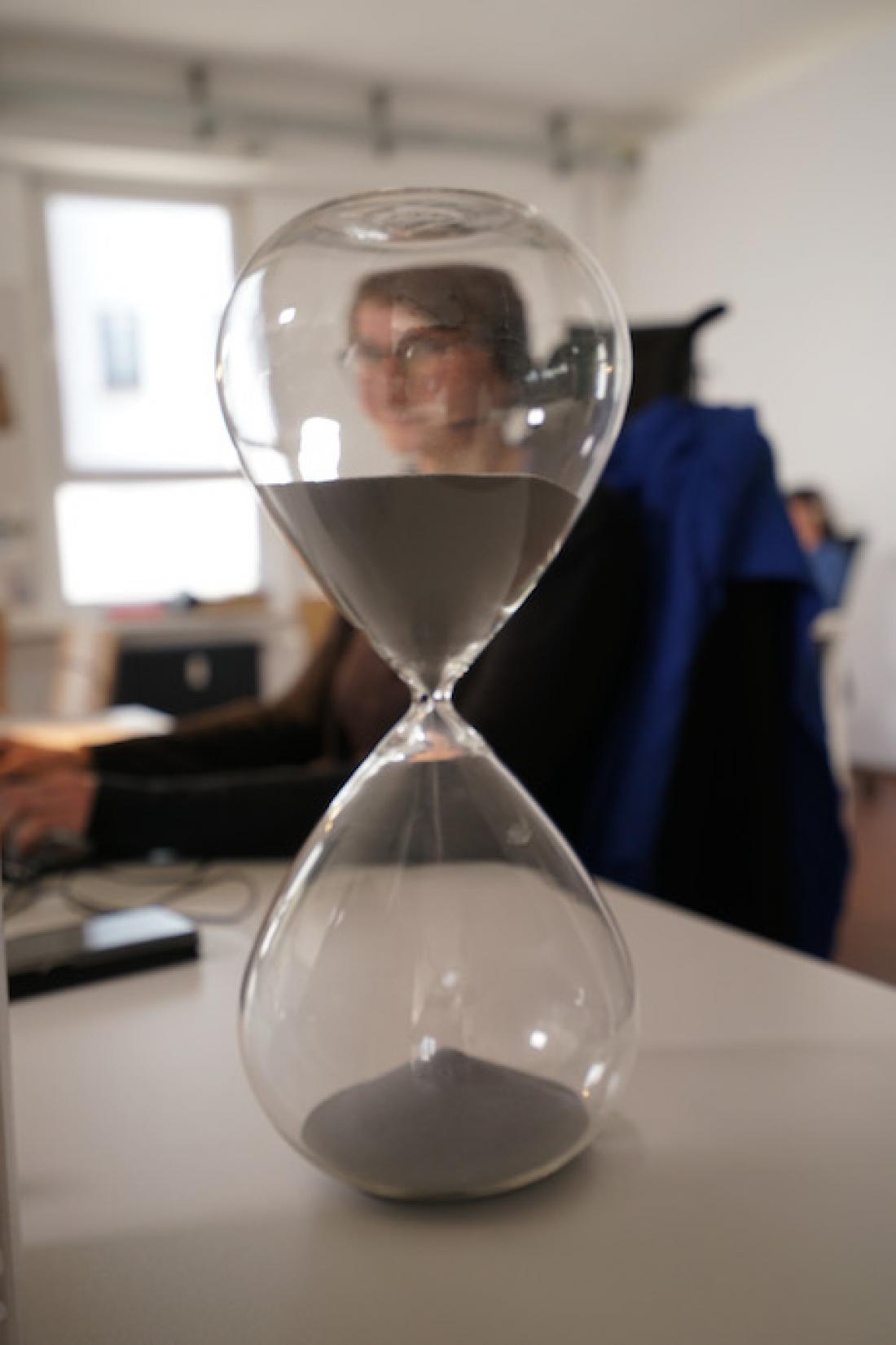 Blick auf Julia Pierzina, Co-Organisatorin des Kick-Offs von Coding da Vinci Saar-Lor-Lux 2020, durch eine Sanduhr