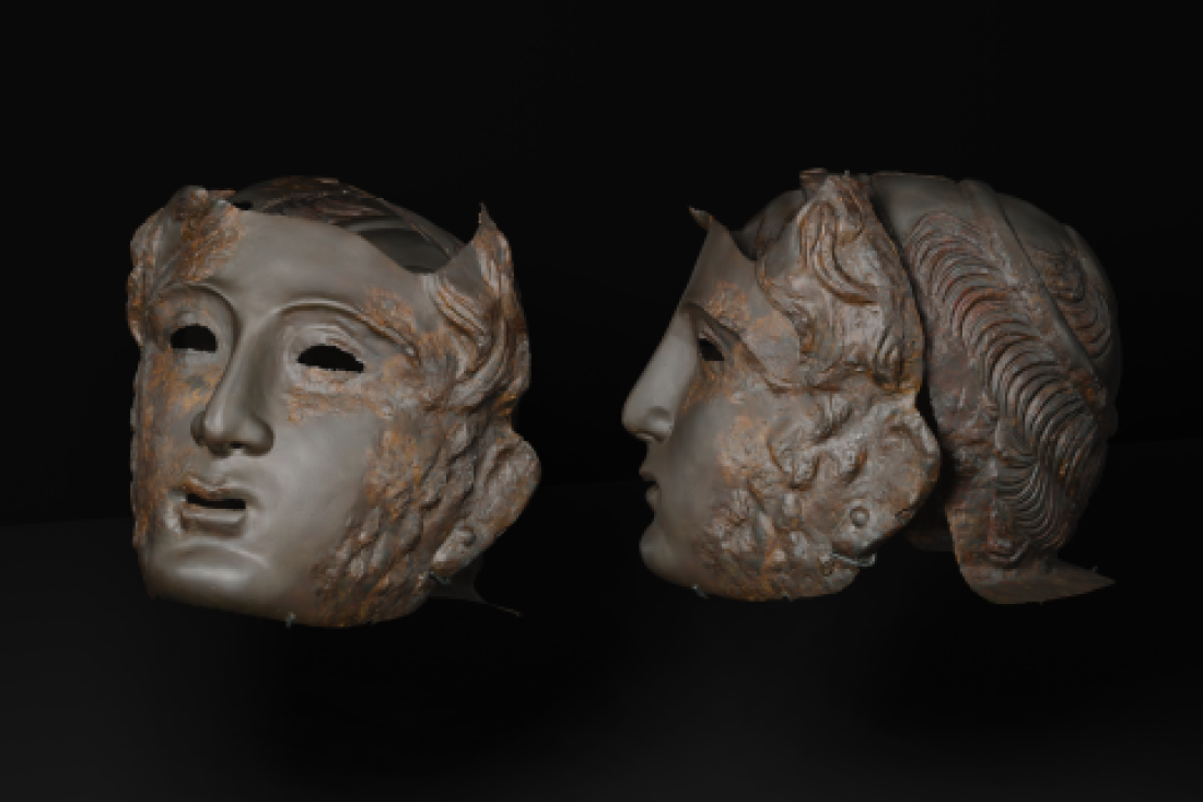 Zwei römische Masken, eine frontal, eine seitlich vor schwarzem Hintergrund