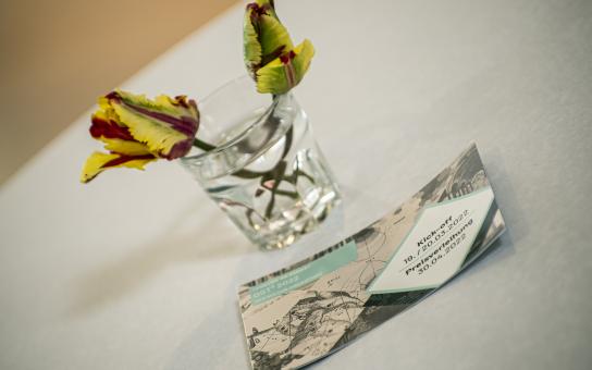 Eine kleine Blumenvase mit zwei Blümchen, davon der CdV-Ost-Flyer